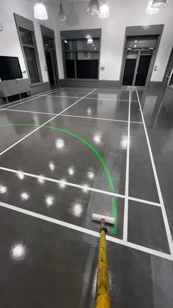 Resilient sports court floor in Stratford with fresh white and green line markings.