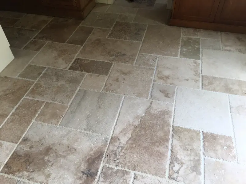 Beige and brown stone tile floor with varied rectangular pattern indoors