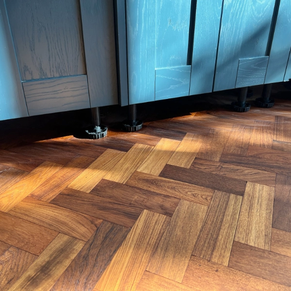 Close-up of a professionally varnished parquet floor, showcasing a warm, rich finish with natural wood grain enhancement.