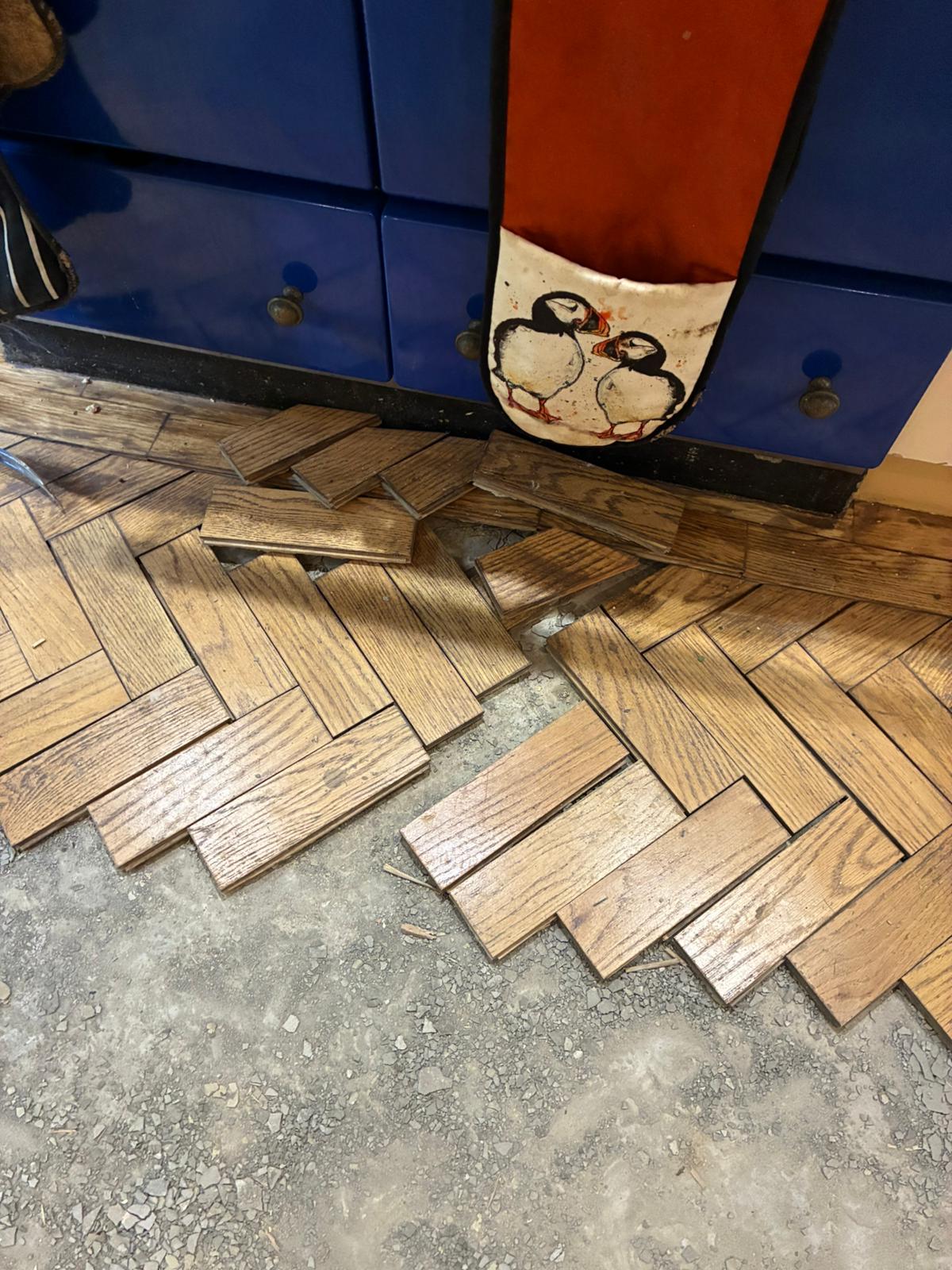 Damaged oak parquet floor beside Aga before repair in Angel, London