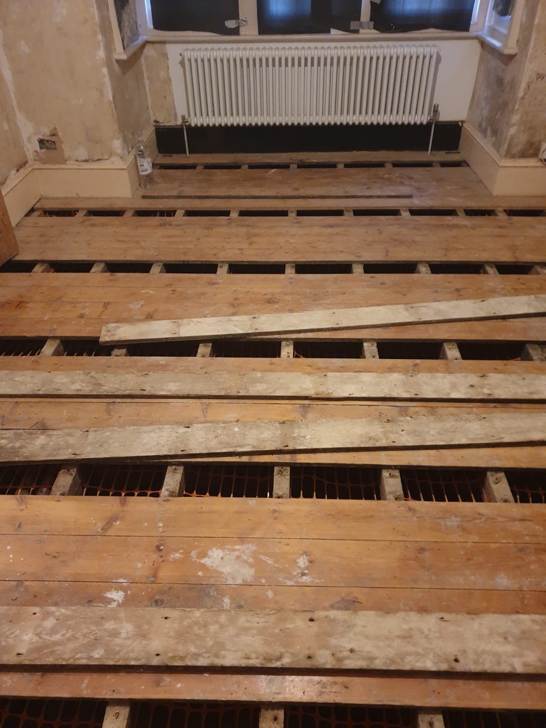 Wood floor restoration preparation with exposed floorboards in a London property