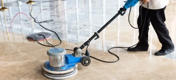Close-up of marble polishing machine in use on a beige floor