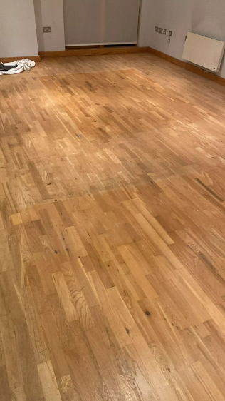 Oak floors in Fish Islands, Stratford, London, before sanding, showing wear, scuffs, and uneven patches.
