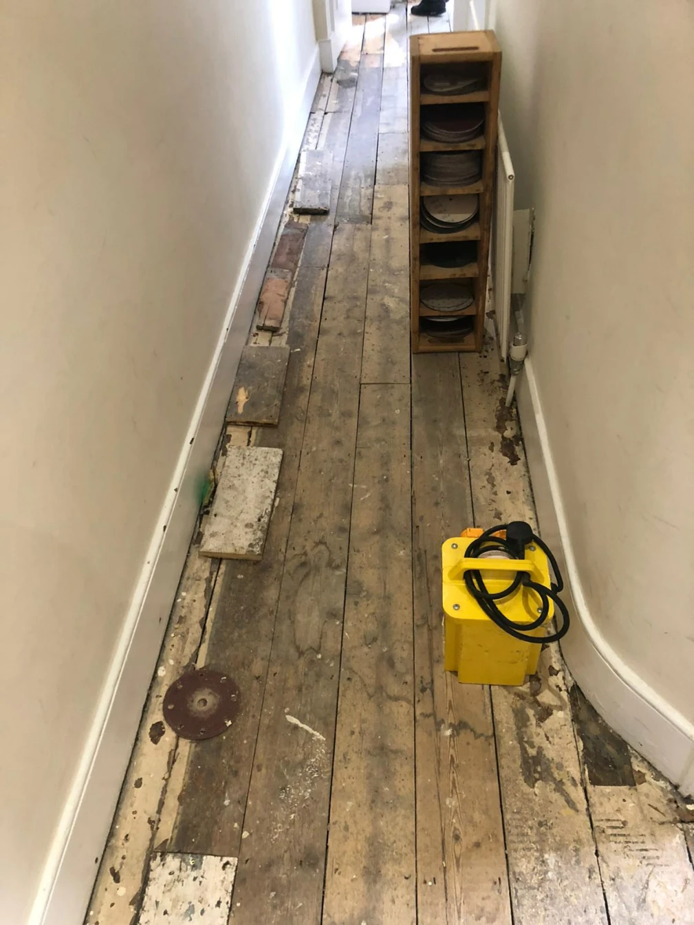 Damaged pine floorboards in a London hallway