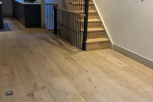 Oak flooring and stairs refinished with a subtle white finish in a Kensington home, showcasing seamless transitions and natural tones.